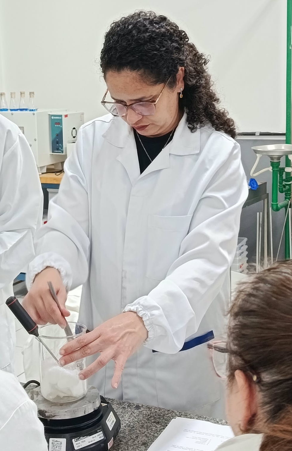 Estudante do Curso de Licenciatura em Química realizando uma exposição prática da temperatura ideal para derretimento da cera de côco. Produção de velas aromáticas vinculada à Prática como Componente Curricular (PCC) cujo tema foi a Lavanda